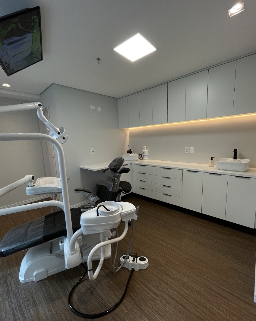Consultório clínico com tecnologia odontológica contemporânea, iluminação precisa e alto rigor de biossegurança
